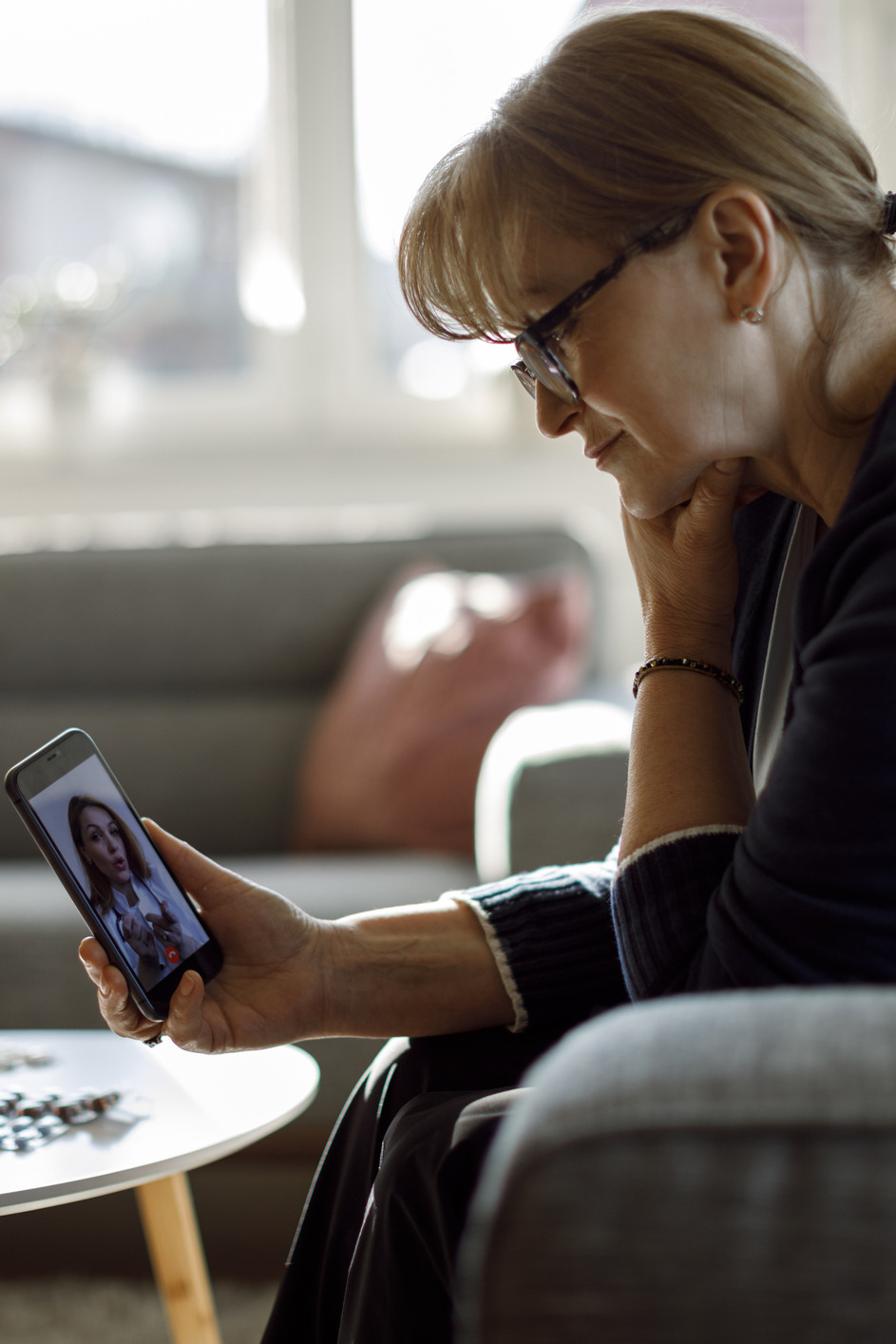 smiling woman talks with other woman via smartphone