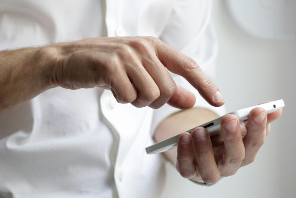 man typing into smartphone